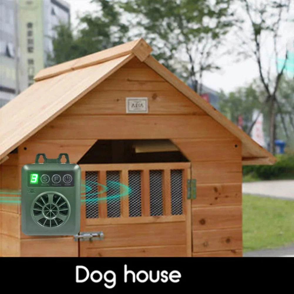 A wooden dog house with a sloped roof and a barred entrance, featuring an ultrasonic anti-barking device.