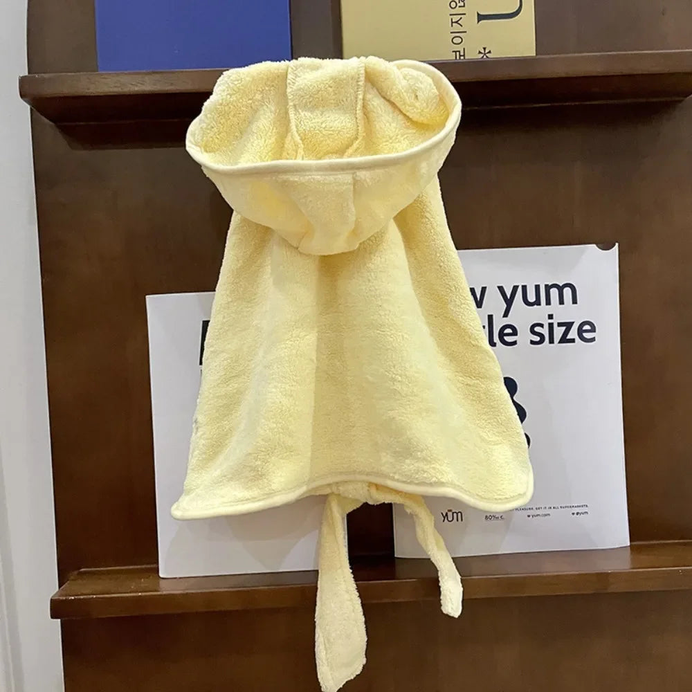A yellow multi-purpose pet bath robe for dogs hanging on a wooden shelf.