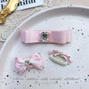 Pink bow hair accessory featuring a rhinestone and pearl accent for children's hair