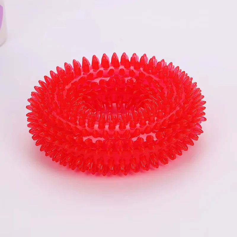 A bright red spiky squeaky dog chew toy for dental care