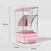 A pink automatic parrot feeder with a clear dome and a separate husk compartment.