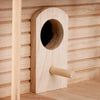 A wooden hanging birdhouse with a circular entrance hole and a small perch mounted on a light wood panel.