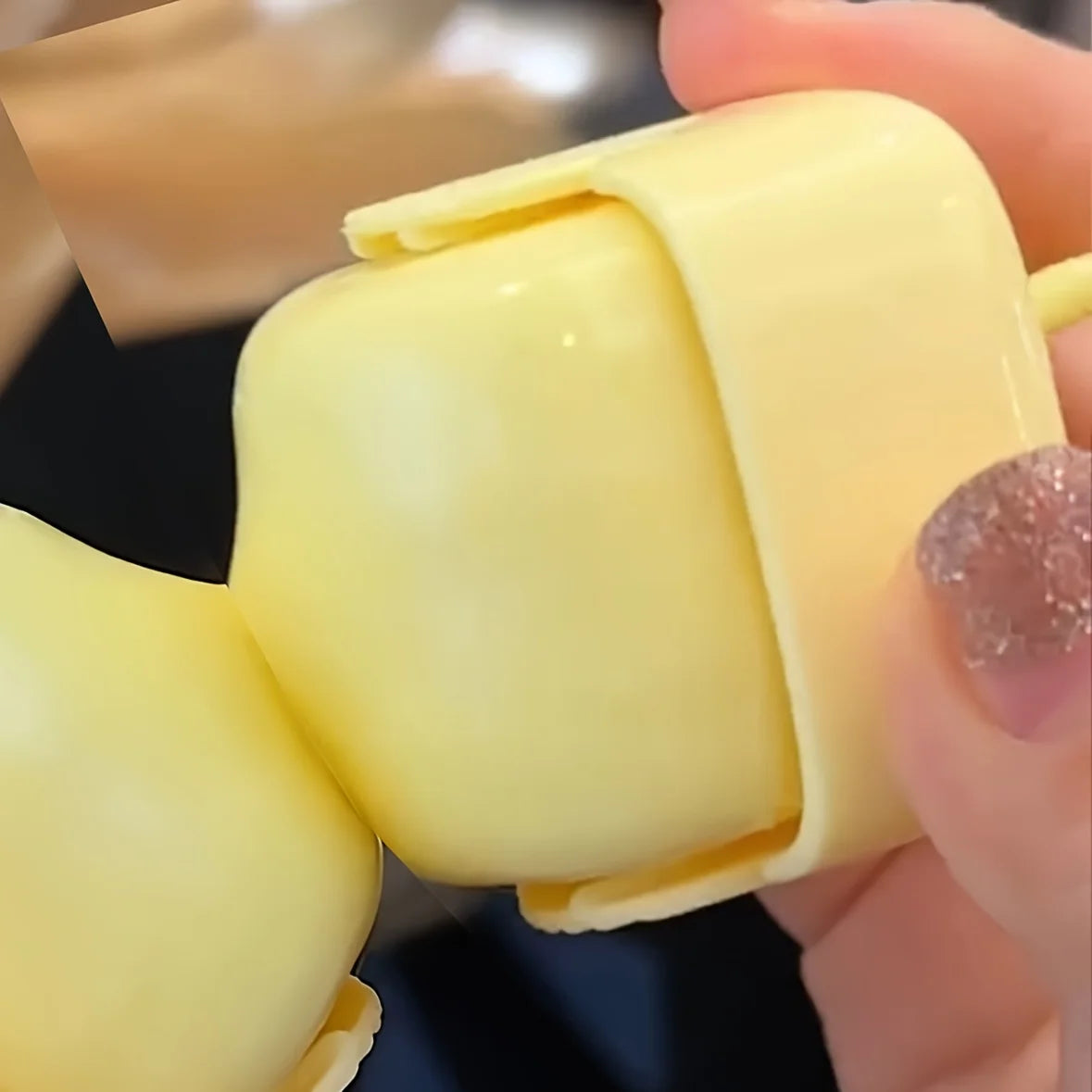 A hand holds a yellow portable lint roller for pet hair removal, showing the roller's surface.
