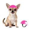 A small dog wearing a bright pink pet safety helmet and goggles.