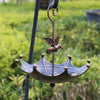 Antique umbrella bird feeder with a bath bowl hanging from a metal hook.