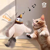 A fluffy cat toy resembling a bird is interacting with a tabby cat in a domestic setting.