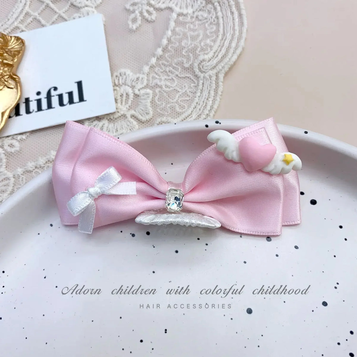 Pink bow hair accessory for children with white feathers and rhinestone pearl accents