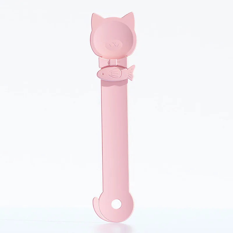 A pink long-handled pet food dispensing spoon with a cat head design.