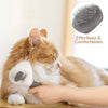 A hand is using a grooming brush on a cat's fur to remove pet hair.