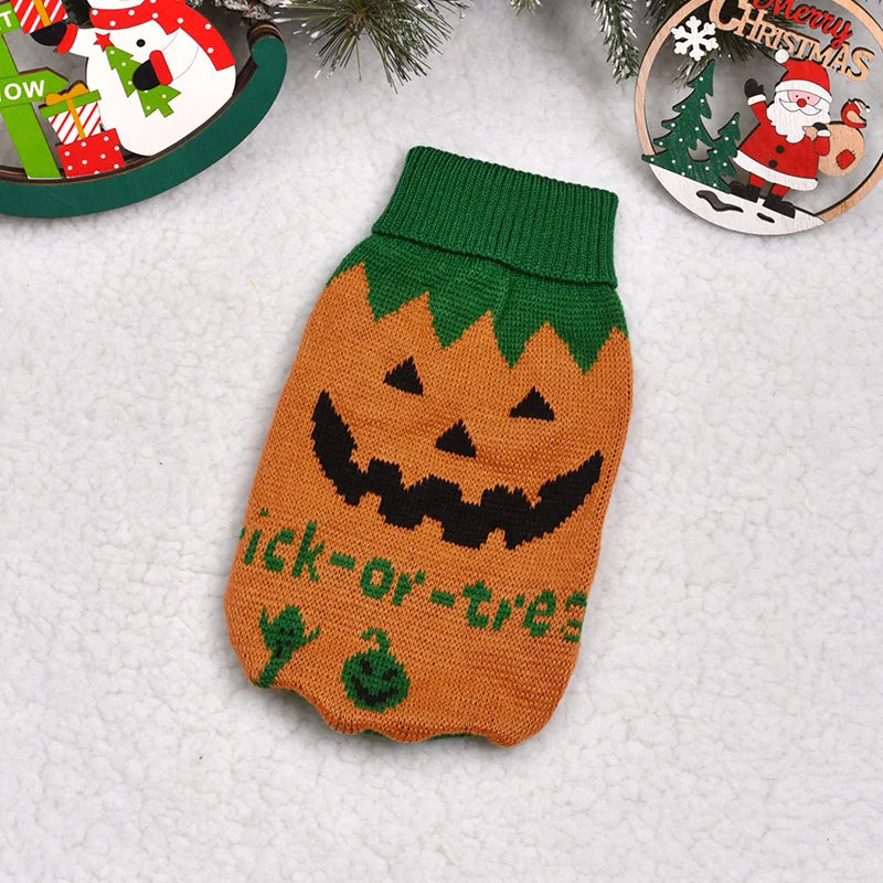 A knitted orange pumpkin shaped dog sweater with a black carved face and green details.