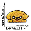 A yellow embroidered patch of a puppy face with black details.