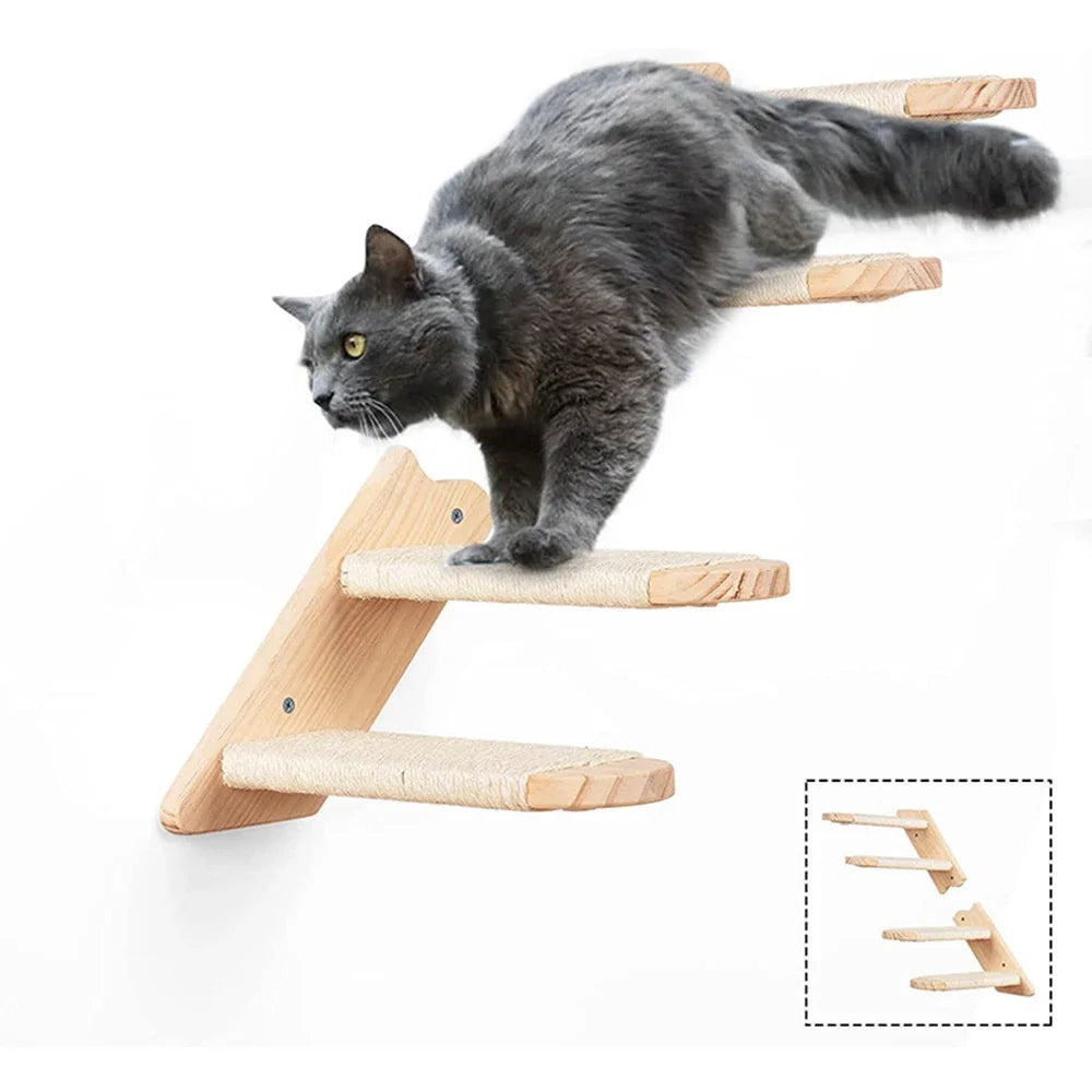 A gray cat is climbing on a wooden wall-mounted shelf and hammock for play.
