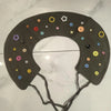 A dark gray silicone collar for pets featuring various colored, star-shaped and round plastic embellishments.