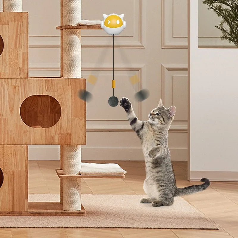 A gray cat interacts with an automatic lifting toy ball that is suspended from a wooden structure.