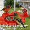 A red backyard sanctuary feeder with a hummingbird feeding station and a bird perched on it.