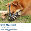 An orange dog wearing a black soft material muzzle while lying on green grass.