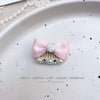 Pink bow hair accessory featuring a rhinestone and pearl accent clip