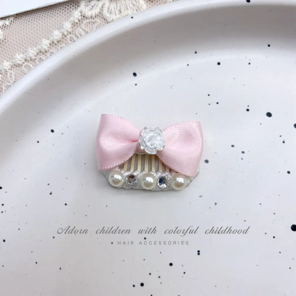 Pink bow hair accessory featuring a rhinestone and pearl accent clip