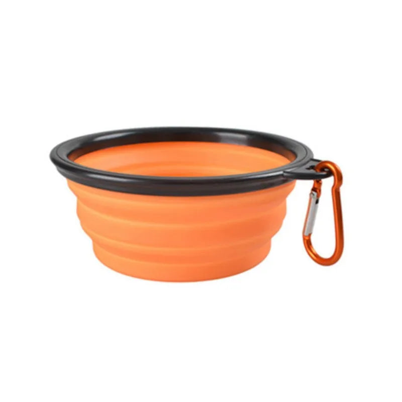 An orange collapsible silicone pet travel bowl with a black rim and attached carrying loop.