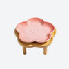 Bol à animaux en céramique rose avec motif cœur, exposé sur un support en bois naturel.