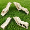Three wooden hamster hideout caves with peekaboo designs arranged on green grass.