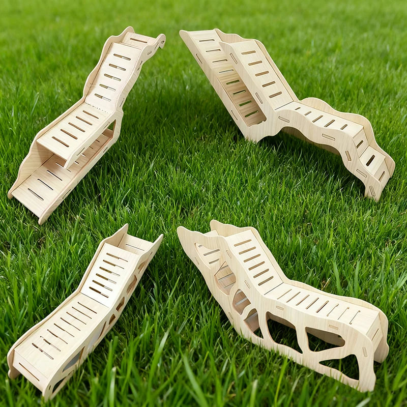 Three wooden hamster hideout caves with peekaboo designs arranged on green grass.
