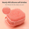 A pink silicone pet bath massage brush with soft bristles shown on a light background.
