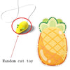 A yellow cat toy is shown being attached to a wall-mounted cat scratcher.