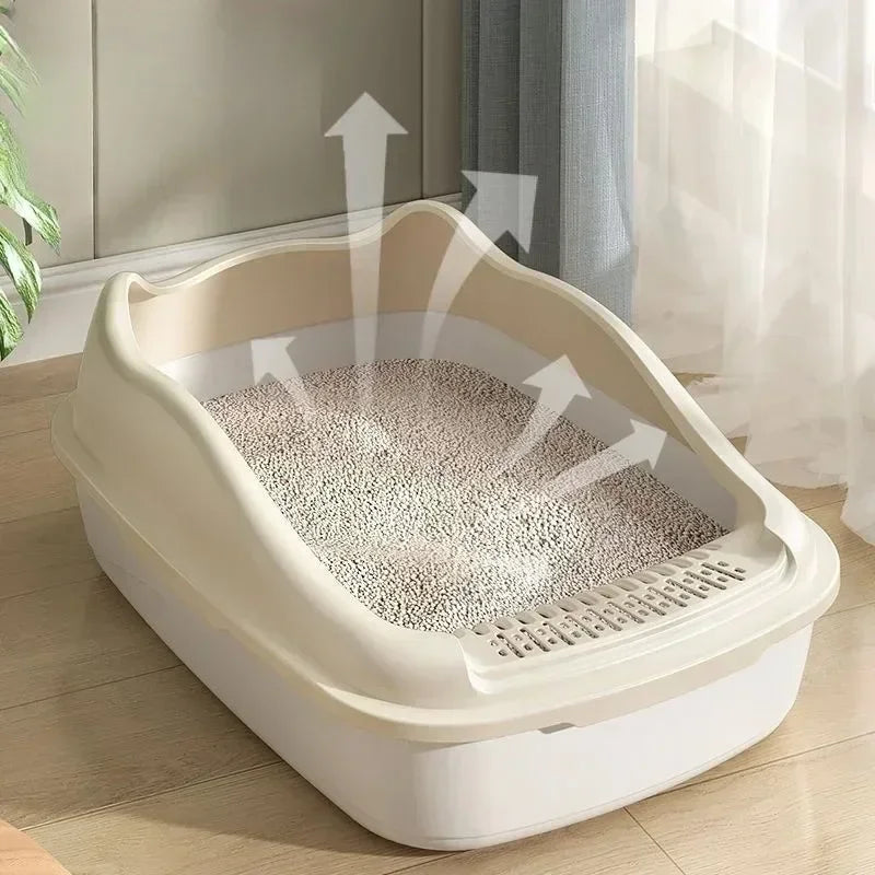 A beige high-sided cat litter box with a mesh bottom is shown on a wooden floor.