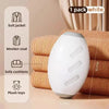 A white reusable gel lint roller is shown resting on a stack of beige fabric and next to various household items.