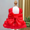 A bright red solid color pet dress with a large bow and D-ring for a small dog