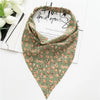 A close-up of a Bohemian paisley triangle scarf in olive green with floral patterns.