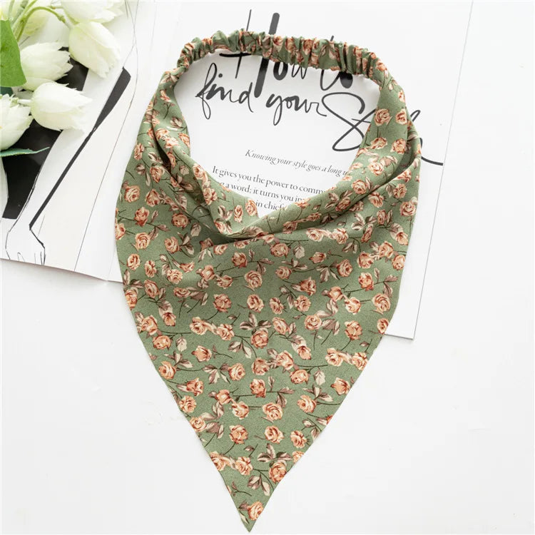 A close-up of a Bohemian paisley triangle scarf in olive green with floral patterns.