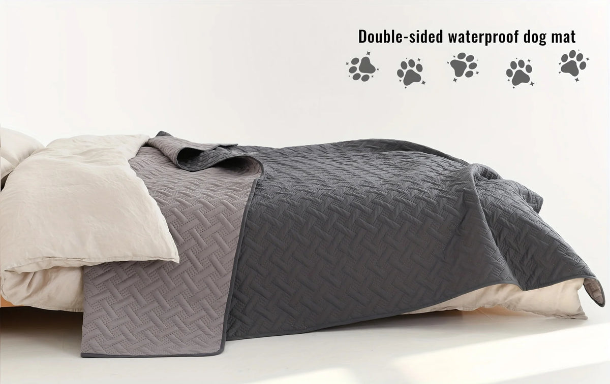 A gray double-sided waterproof dog mat is shown folded next to a light-colored pillow.