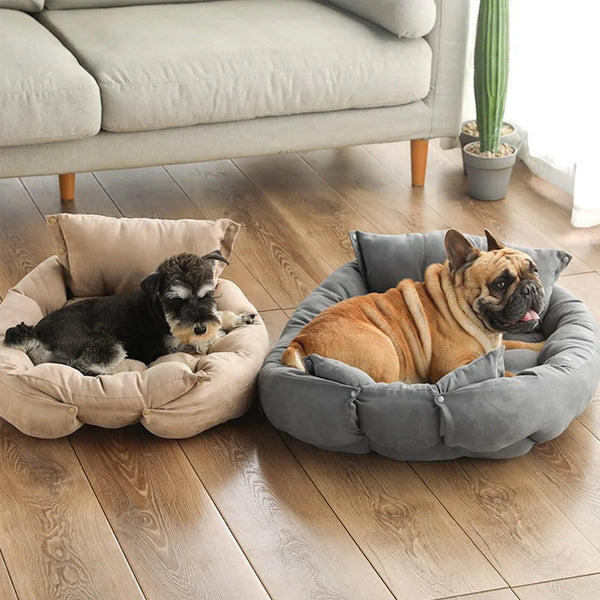A plush gray pet sofa bed with a raised rim is shown on a wooden floor, with a dog resting inside.