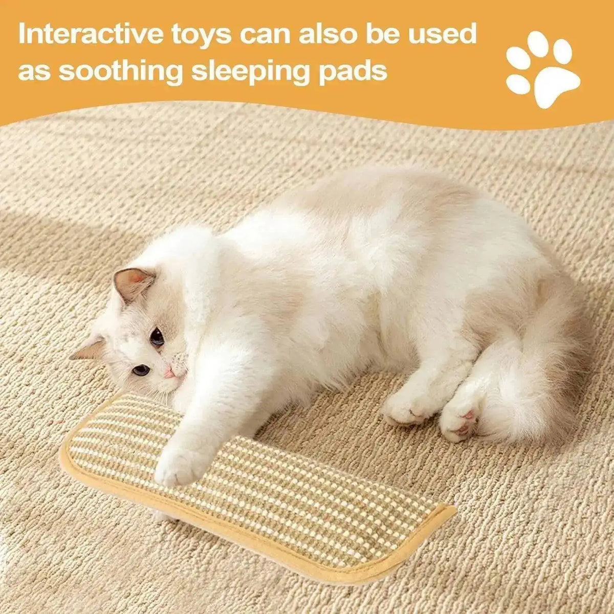 A white cat is lying on a beige fabric with an interactive toy used as a soothing sleeping pad.