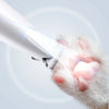Nahaufnahme einer Katzenpfote, die mit einem LED-Licht und einem Elektrowerkzeug zum Nageln und Trimmen bearbeitet wird.