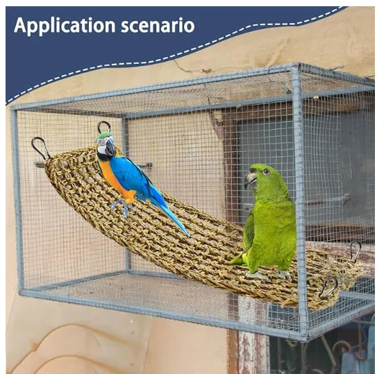 Ein blau-orange Papagei sitzt auf einer geflochtenen Hängematte in einem Drahtkäfig.