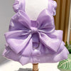 A lavender satin pet dress with a large bow and D-ring for a small dog displayed on a mannequin.