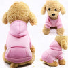 A fluffy golden retriever wearing a pink hooded sweatshirt for dogs.