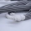 A close-up of a cartoon skeleton dog plush toy with white paws and black and white striped fabric.