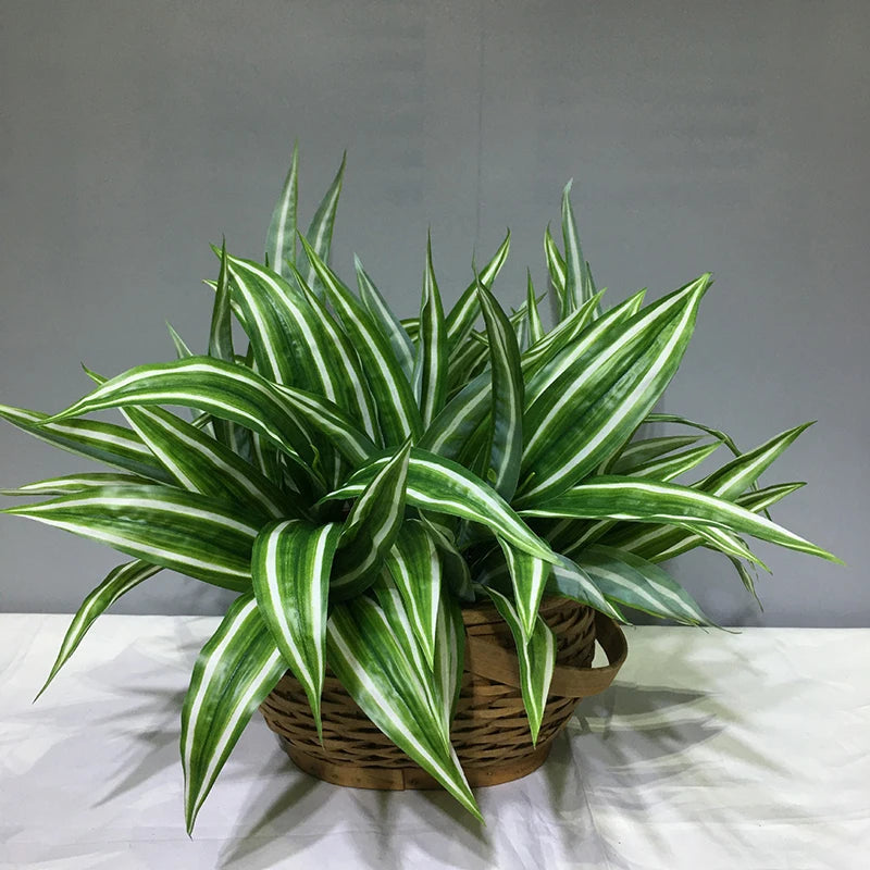 A vibrant green artificial tropical palm plant with striped leaves potted in a woven basket.