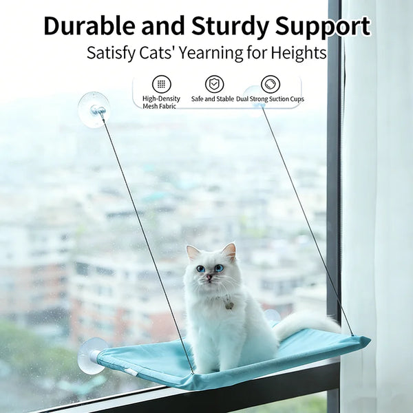 A white cat is sitting on a blue hanging hammock window perch, demonstrating durable and sturdy support.