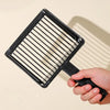 A black plastic cat litter scoop with a hanging hook is held by a hand.