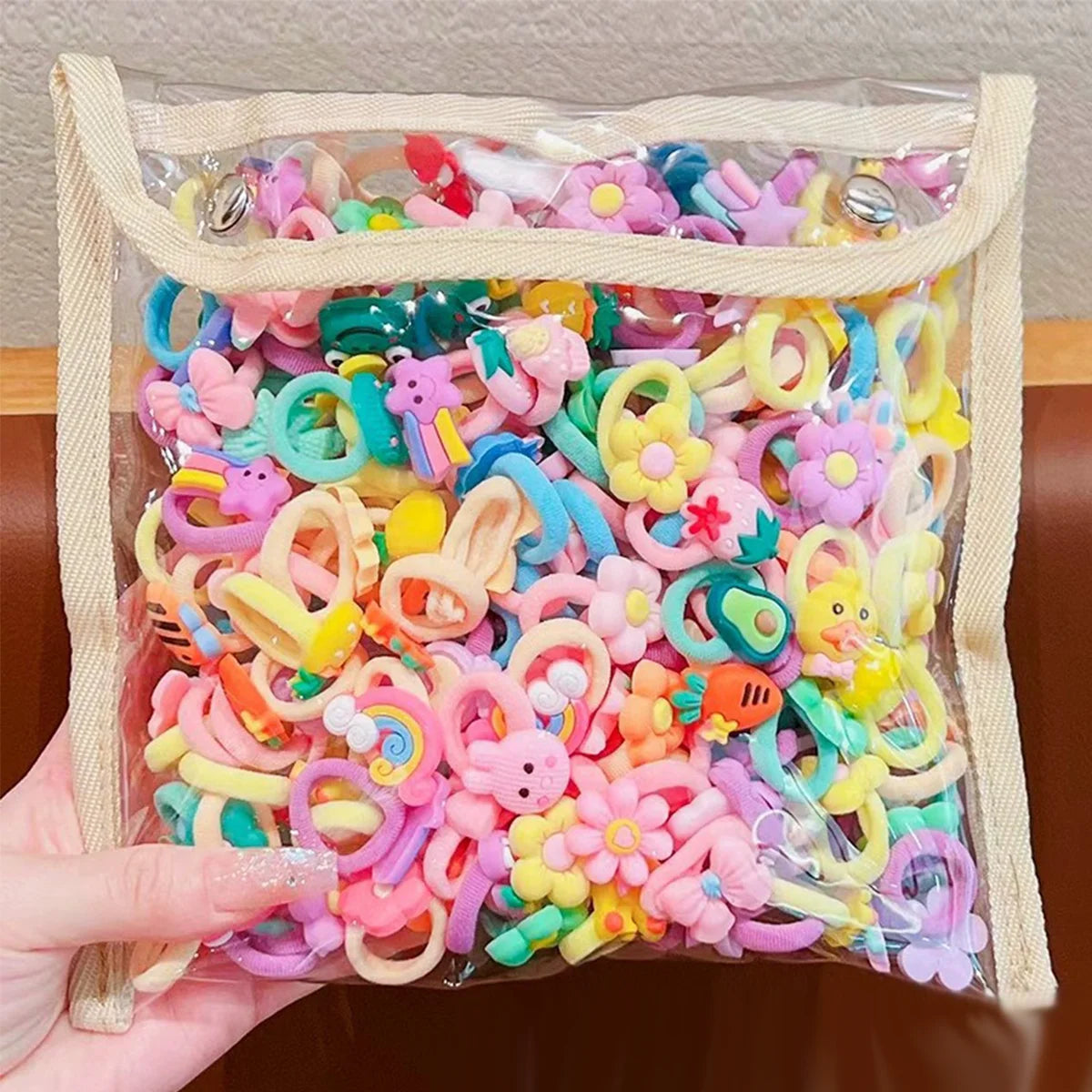 Klare Plastiktüte mit einer großen Packung bunter Cartoon-Haargummis für Mädchen