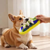 A light brown and white dog is holding a yellow squeaky slipper toy with a rope.