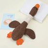 A brown plush toy shaped like a duck with orange feet and an orange beak, resting on a white box.