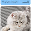 A fluffy gray and white cat is resting on a gray honeycomb litter mat.