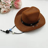 A brown felt cowboy hat with a black band and leather cord, resting on a white surface next to pink flowers.