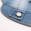 Close-up of a classic blue denim dog jacket showing a metal button detail on the fabric.